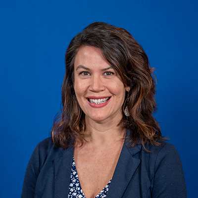 A white woman in her 30s with medium-length brown hair, smiling for her photo.